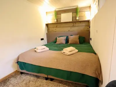 a bedroom with a bed with two towels on it at Sonnig Bungalow in Lanaken