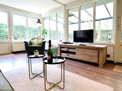 a living room with a couch and a tv at Sonnig Bungalow in Lanaken