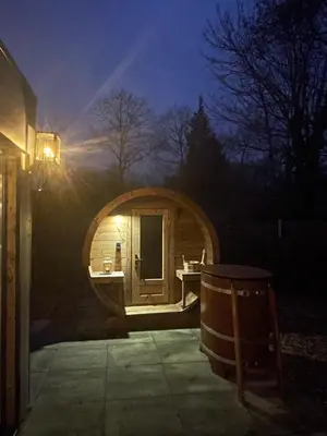 a small wooden sauna with a tub in the dark at Lacuna VITA by Sonnevijver Residences in Lanaken