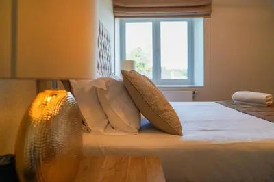 a bedroom with a bed with pillows and a window at Hôtel Au Comte de Mercy in Oupeye