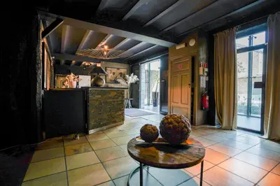 a living room with a table and a kitchen at Hôtel Au Comte de Mercy in Oupeye