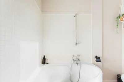 a white bath tub in a white tiled bathroom at 8P 4B Authentic house with playroom and infrared sauna in Bilzen