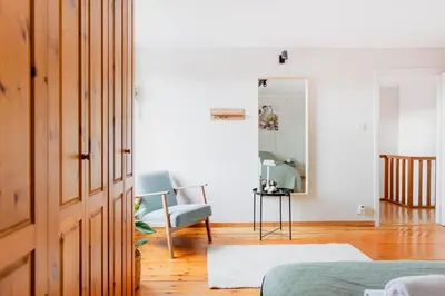 a living room with a blue chair and a mirror at 8P 4B Authentic house with playroom and infrared sauna in Bilzen