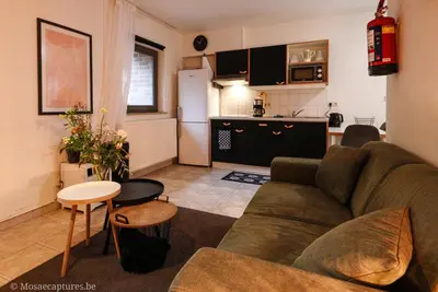a living room with a couch and a kitchen at De Millenniumhoeve (Jean) in Riemst