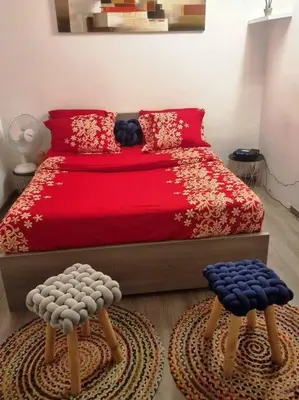a bedroom with a red bed with two ottomans at Appartement très proche médiacité - centre ville in Liège