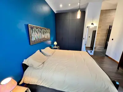 a blue bedroom with a large bed with a blue wall at Art Loft -Opéra, Saint-Lambert, Bueren in Liège