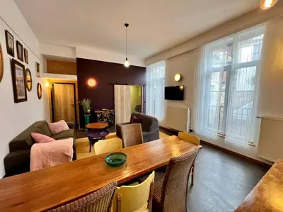 a living room with a wooden table and chairs at Art Loft -Opéra, Saint-Lambert, Bueren in Liège