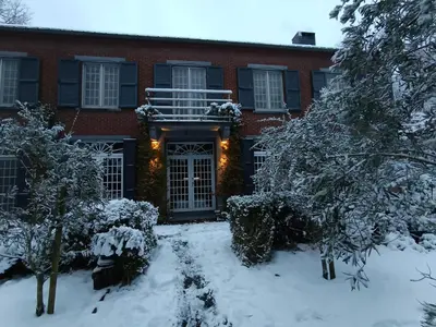 a house with a snow covered yard in front of it at Sleep and Dream in Liège