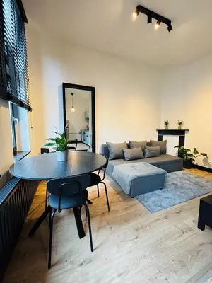 a living room with a table and a couch at Appartement Cosy Liège Station in Liège