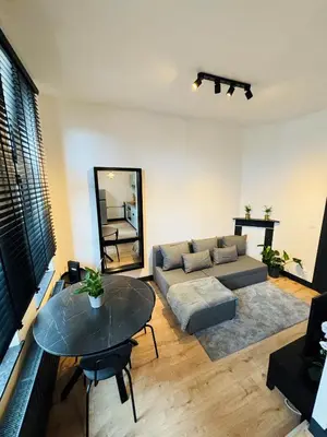 a living room with a couch and a table at Appartement Cosy Liège Station in Liège