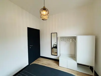 a room with a white refrigerator and a mirror at Appartement Cosy Liège Station in Liège