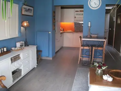 a kitchen with blue walls and a table and a counter at Apartment Het Demerhuisje in Hasselt