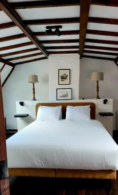 a bedroom with a large white bed with two lamps at De Pelgrim in Tongeren