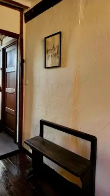 a wooden bench sitting in a room with a wall at De Pelgrim in Tongeren