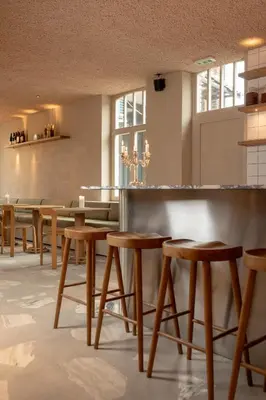 a bar with wooden stools in a restaurant at Luxe in Het Posthuis - nieuwe Stijlvolle Verblijven in Oud-Rekem in Lanaken