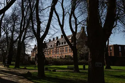 a large building in the middle of a park with trees at Luxe in Het Posthuis - nieuwe Stijlvolle Verblijven in Oud-Rekem in Lanaken