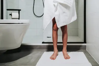 a person standing on a white towel in a bathroom at Huisje Mezengroet in Lanaken