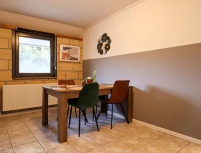 a dining room with a wooden table and chairs at Millenniumhoeve (Lieke) in Riemst