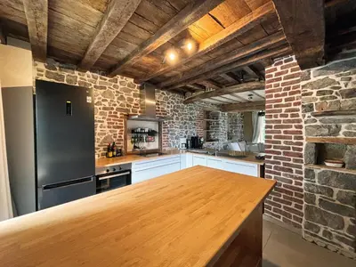 a kitchen with a wooden counter and a brick wall at Close from Ardenne - Fully renovated modern farmhouse in Baelen in Baelen