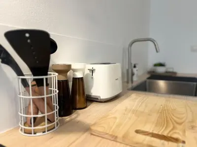 a kitchen counter with utensils and a kitchen sink at L'escapade chic - Cathédrale, Saint Lambert in Liège