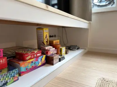 a shelf with books and other items on it at Duplex chic et spacieux - Hypercentre in Liège