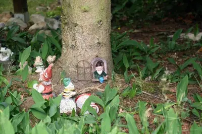 a group of figurines in front of a tree at Vakantie Bos Huisje “Meibloempje” in Lanaken