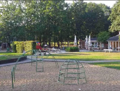 a playground in a park with a slide at Vakantie Bos Huisje “Meibloempje” in Lanaken