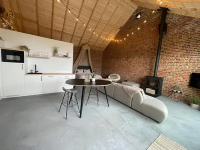a living room with a couch and a table at Boven de paarden @ de Hoeveschuur in Riemst