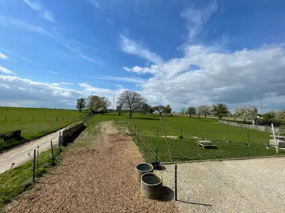 a dirt road with buckets on the side of a field at Boven de paarden @ de Hoeveschuur in Riemst