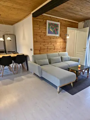 a living room with a couch and a table at Cozychalet met prive Hot tub in Lanaken