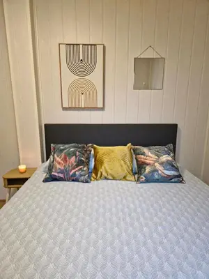 a bed with two pillows on top of it at Cozychalet met prive Hot tub in Lanaken