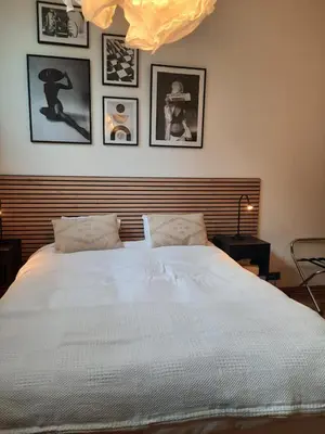 a bedroom with a large white bed with pictures on the wall at Superbe loft de caractère avec garage à 10' du centre in Liège
