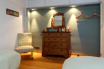 a bedroom with a dresser with a mirror and a chair at Superbe loft de caractère avec garage à 10' du centre in Liège