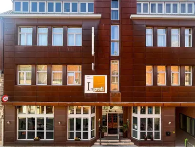a large brown building with a sign on it at Hotel INGREDI in Bree