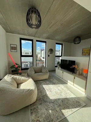 a living room with two chairs and a flat screen tv at PentHouse 5.01 in Liège
