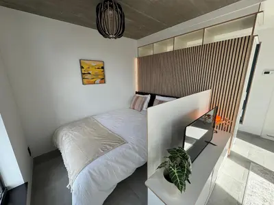 a small bedroom with a bed and a mirror at PentHouse 5.01 in Liège