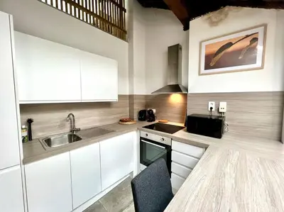 a kitchen with white cabinets and a sink at Le Belvédère de la Rose-Hors château, hypercentre in Liège
