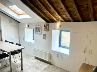 a kitchen with white cabinets and a table and a window at Le Belvédère de la Rose-Hors château, hypercentre in Liège