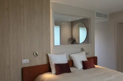 a bedroom with a bed with a mirror on the wall at Hôtel Les Fines Gueules in Herve
