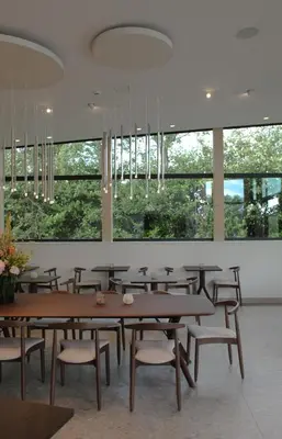 a dining room with tables and chairs and large windows at Hôtel Les Fines Gueules in Herve