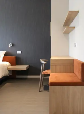 a bedroom with a bed and a desk and a chair at Hôtel Les Fines Gueules in Herve