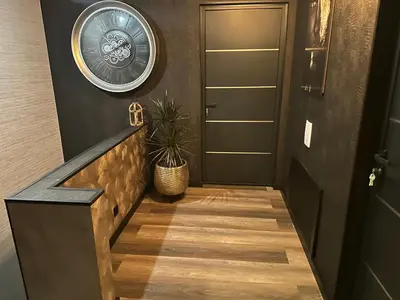 a hallway with a black door and a clock on the wall at Tranquilo Maaseik in Maaseik
