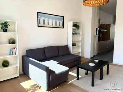 a living room with a couch and a table at Le Botanique des Augustins -100m2 en plein centre in Liège