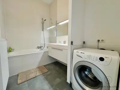 a white bathroom with a washing machine in a bathroom at Le Botanique des Augustins -100m2 en plein centre in Liège