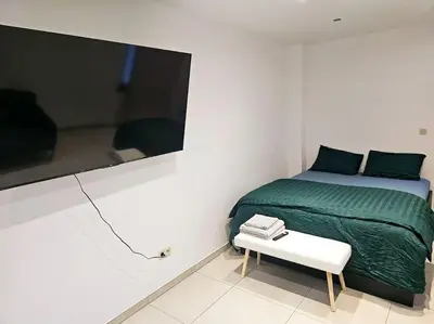 a bedroom with a bed and a small table at appartement ouvert sur une pièce in Liège