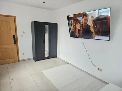 a flat screen tv on a wall in a room at appartement ouvert sur une pièce in Liège