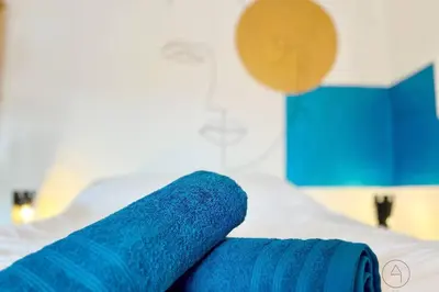 a pair of blue towels sitting on top of a bed at Le parfait Studio de la Cité Ardente - Central in Liège
