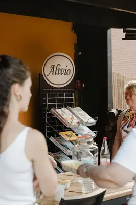 two women standing at a table in front of a sign at Alivio - Thuiskomen bij jezelf op vakantie in Lummen