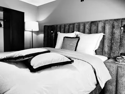 a bedroom with a large bed with white sheets and pillows at Garden Street Lommel - The Green Haven in Lommel