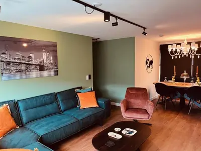a living room with a blue couch and a table at Garden Street Lommel - The Green Haven in Lommel